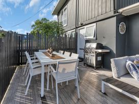 An outdoor area with a dining table and barbecue grill at Matapouri Magic - Matapouri