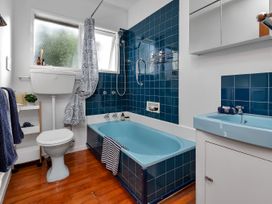 A bathroom with a bathtub, toilet, and sink at Matapouri Magic - Matapouri