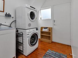 A laundry room with a washing machine and dryer at Matapouri Magic - Matapouri
