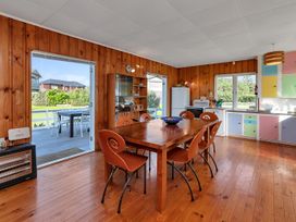A kitchen with a dining table and chairs at Matapouri Magic - Matapouri