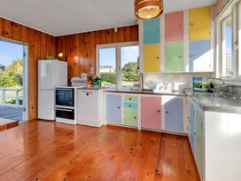 A kitchen with appliance and colorful cabinets at Matapouri Magic - Matapouri