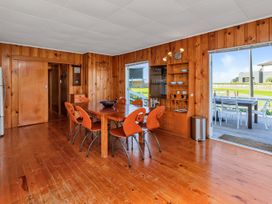 A dining room with a wooden table and chairs at Matapouri Magic - Matapouri