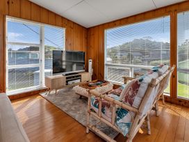 A sunroom with a television and seating area at Matapouri Magic - Matapouri