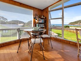 A sunroom with a table and chairs at Matapouri Magic - Matapouri