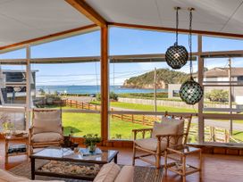 A living room with window view at Matapouri Magic - Matapouri