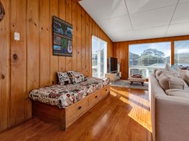 A living room with a seating area and television at Matapouri Magic - Matapouri