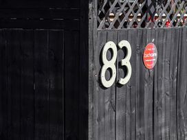 A number 83 and a sign on a fence at Manaia Magic - Tairua Holiday Home, Tairua