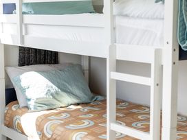 A bunk bed with sheets and pillows at Manaia Magic - Tairua Holiday Home, Tairua