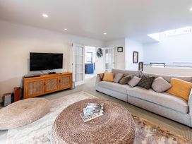 A living room with a television and sofa at Manaia Magic - Tairua Holiday Home in Tairua