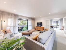 A living room with a sofa and a TV at Manaia Magic - Tairua Holiday Home, Tairua