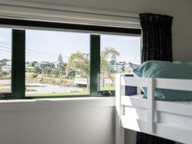 A bedroom with a bunk bed and a view of the landscape at Manaia Magic - Tairua Holiday Home Tairua