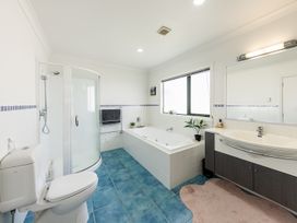 A bathroom with toilet, shower, bathtub and sink at Manaia Magic - Tairua Holiday Home Tairua