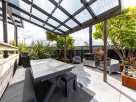An outdoor patio with seating and a fireplace at Manaia Magic - Tairua Holiday Home, Tairua