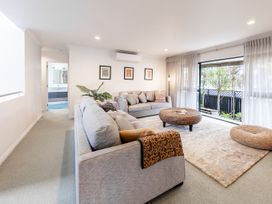 A living room with a sofa and coffee table at Manaia Magic - Tairua Holiday Home, Tairua
