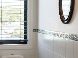 A bathroom with a mirror and window at Manaia Magic - Tairua Holiday Home, Tairua