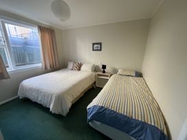 A bedroom with a double bed and a single bed at Le Solterre - Akaroa Holiday Home in Akaroa