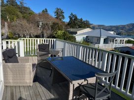 A seating area with a table and chairs on the deck at Le Solterre - Akaroa Holiday Home Akaroa