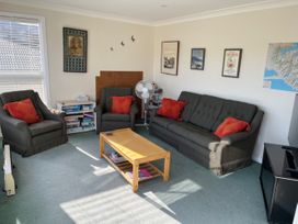 A living room with a sofa and chairs at Le Solterre - Akaroa Holiday Home Akaroa
