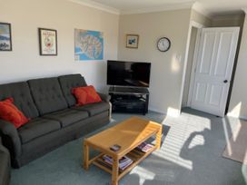 A living room with a sofa and television at Le Solterre - Akaroa Holiday Home in Akaroa