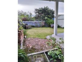 A garden with a grass area and benches at Le Solterre - Akaroa Holiday Home in Akaroa