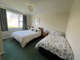 A bedroom with two beds and a window at Le Solterre - Akaroa Holiday Home Akaroa