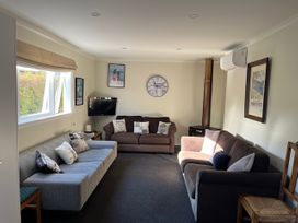A living room with sofas and a television at Le Solterre - Akaroa Holiday Home in Akaroa
