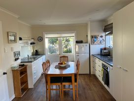 A kitchen with table and chairs at Le Solterre - Akaroa Holiday Home in Akaroa