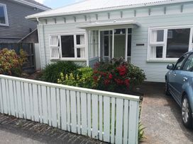 An outdoor view of a house with flowers and a car at Le Solterre - Akaroa Holiday Home Akaroa