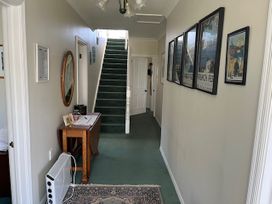 A hallway with a staircase and pictures on the wall at Le Solterre - Akaroa Holiday Home, Akaroa