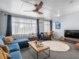 A living room with a sofa, armchair, and television at Bliss on Barratt - Blenheim
