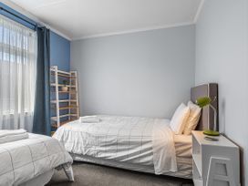 A bedroom with two beds and a shelf at Bliss on Barratt - Blenheim Holiday Home, Blenheim