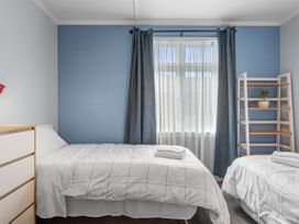 A bedroom with two beds and a shelf at Bliss on Barratt - Blenheim Holiday Home in Blenheim