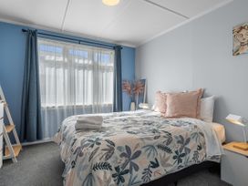 A bedroom with a bed and a shelf at Bliss on Barratt - Blenheim Holiday Home