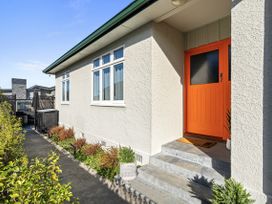 A house entrance with an orange door and plants at Bliss on Barratt - Blenheim Holiday Home