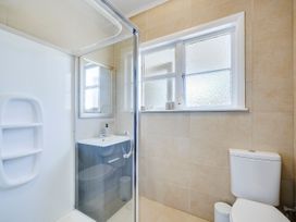 A bathroom featuring a shower, toilet, and sink at Bird and Fish - Napier Holiday Home, Napier