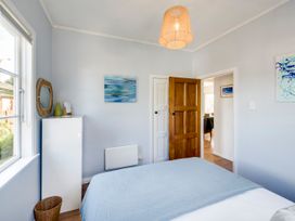 A bedroom with a bed and wardrobe at Bird and Fish - Napier Holiday Home in Napier