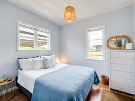 A bedroom with a bed and dresser at Bird and Fish - Napier Holiday Home
