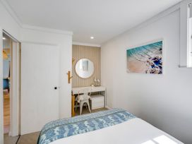 A bedroom with a bed and desk at Bird and Fish - Napier Holiday Home in Napier