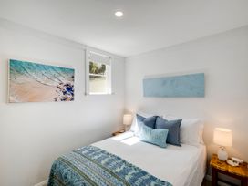 A bedroom with a bed and artwork at Bird and Fish - Napier Holiday Home in Napier