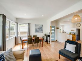 A living room with a dining area and kitchen view at Bird and Fish - Napier Holiday Home, Napier