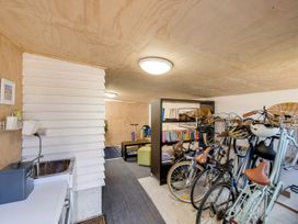 A storage area with bicycles and a bookshelf at Bird and Fish - Napier Holiday Home, Napier