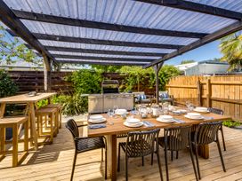 An outdoor dining area with a table and barbecue grill at Bird and Fish - Napier Holiday Home Napier