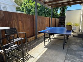 An outdoor area with a ping pong table and seating at Bird and Fish - Napier Holiday Home, Napier