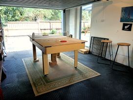 A garage with a table and stools at Ekhaya - New Plymouth Holiday Home, New Plymouth