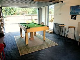 A game room with a pool table and bar stools at Ekhaya - New Plymouth Holiday Home, New Plymouth