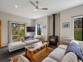 A living room with a sofa and a fireplace at Kokomea House - Wanaka