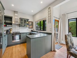 A kitchen with cabinets and appliances at Kokomea House - Wanaka