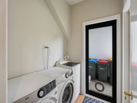 A laundry room with washing machine and dryer at Kokomea House - Wanaka