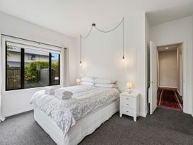 A bedroom with a bed and nightstand at Kokomea House - Wanaka