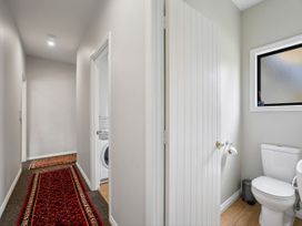 A bathroom with a toilet and washer at Kokomea House - Wanaka